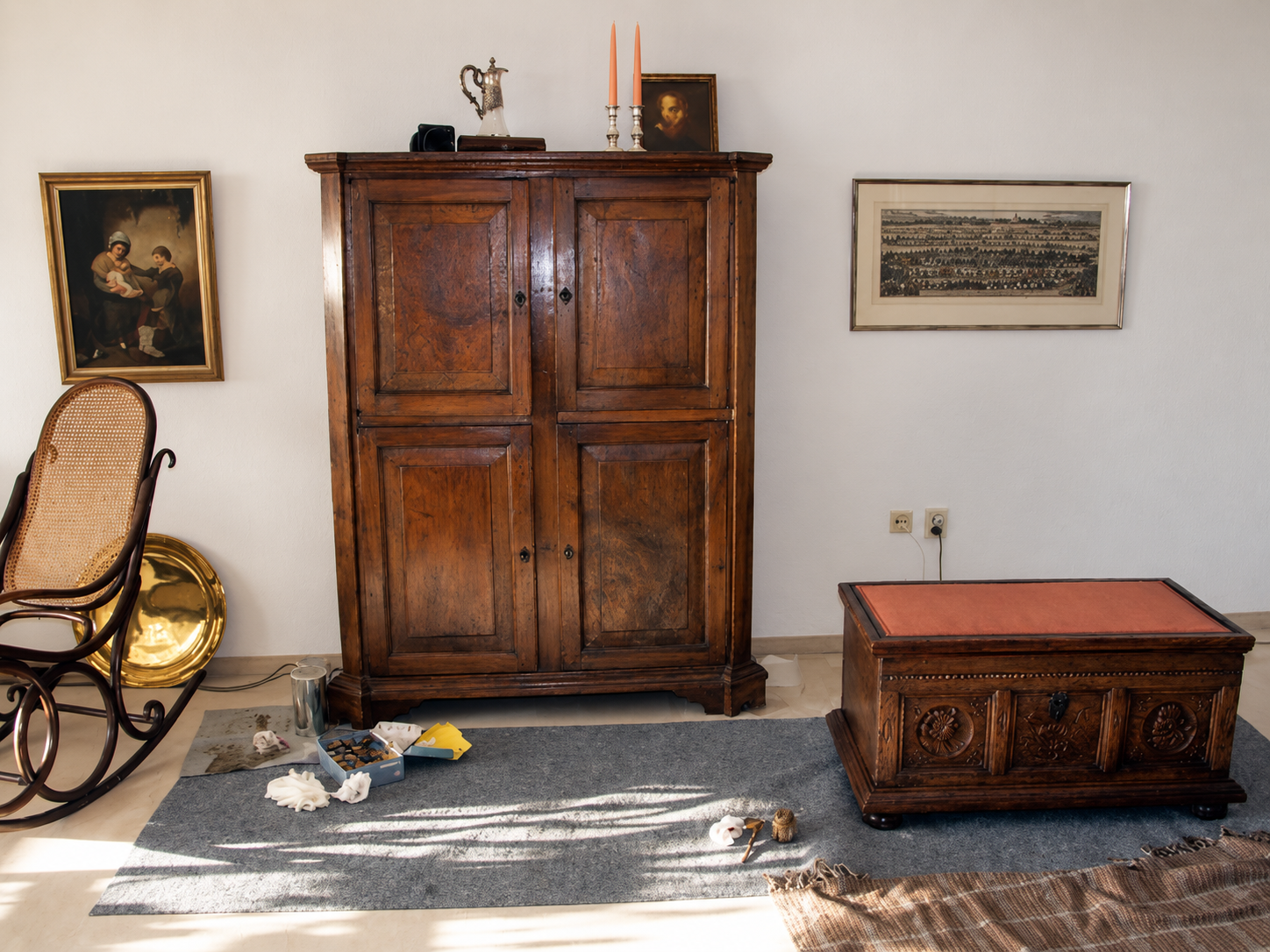 Historischer Schrank, Truhe und Schaukelstuhl mit Arbeitsmaterial im Wohnraum