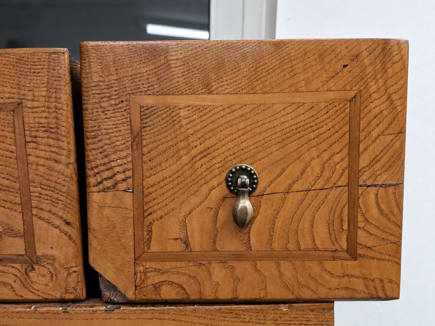 Furnierter Schubkasten mit Messinggriff und deutlicher Holzmaserung